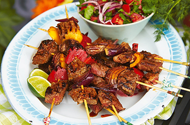 Brazilian-style barbecue beef skewers with tomato salad