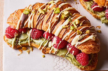 Drizzled croissants with pistachios and raspberries